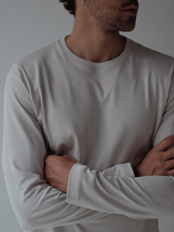 Vista frontal a detalle cuello redondo de camiseta gris manga larga fit regular.