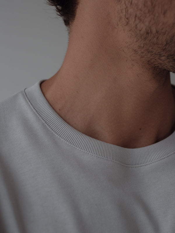 Vista a detalle cuello de camiseta gris manga larga.