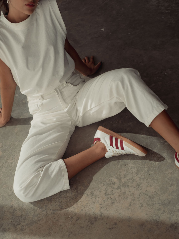 Modelo usando un  conjunto blanco de pantalón y camiseta manga sisa