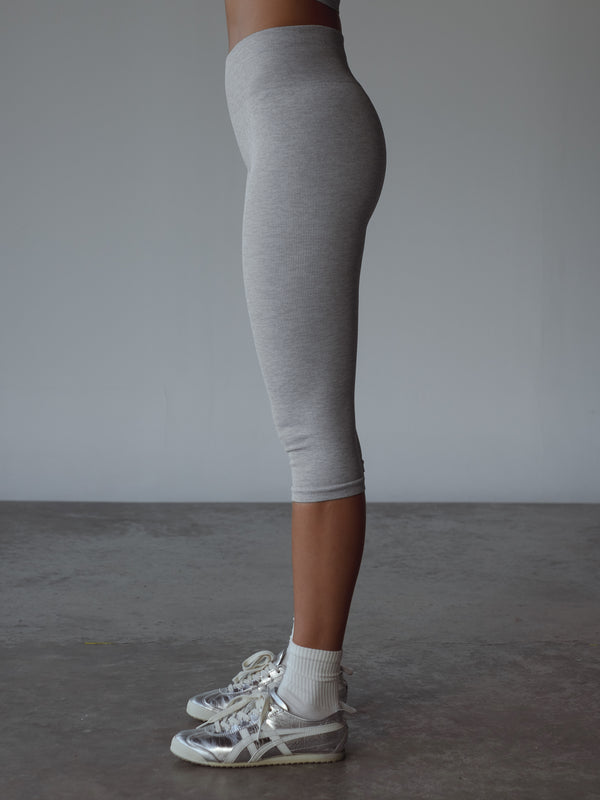 Vista lateral de capri deportivo gris, combinado con medias midi blancas.