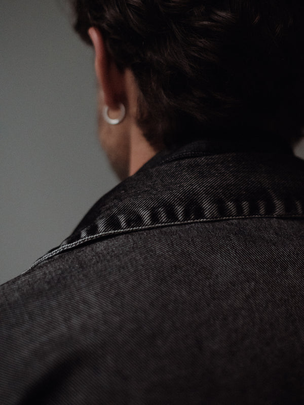 Vista posterior a detalle de cuello de chaqueta negra lavado vintage.