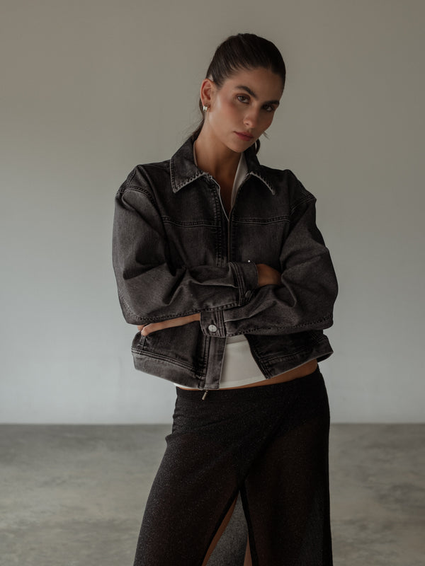 Modelo con chaqueta negra lavado vintage con falda negra de brillos.