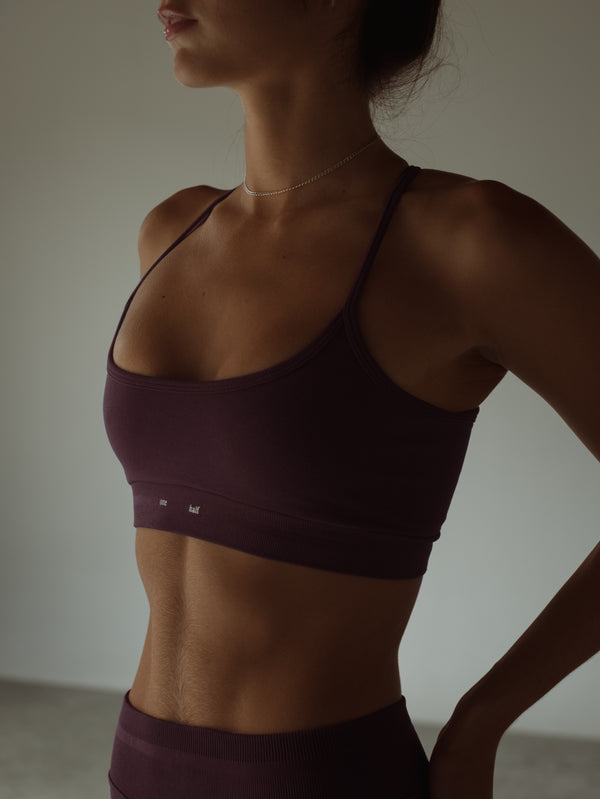 Vista a detalle top deportivo vino de tiras con pretina gruesa.