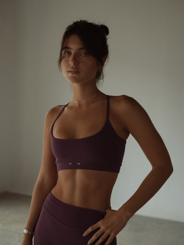 Vista frontal modelo con top deportivo de tiras vino y short.