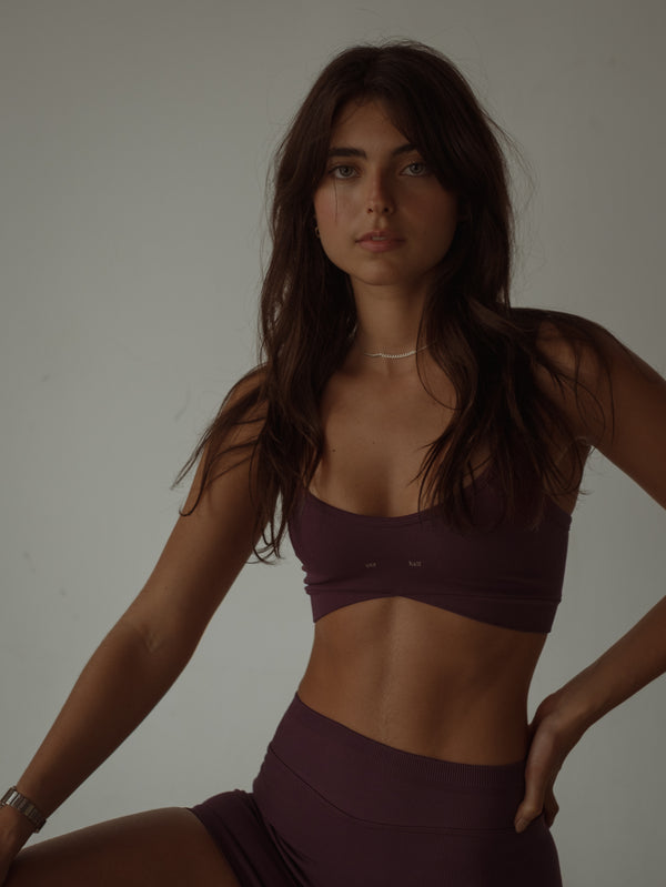 Modelo usando top deportivo vino juste medio de tiras corte asimétrico.