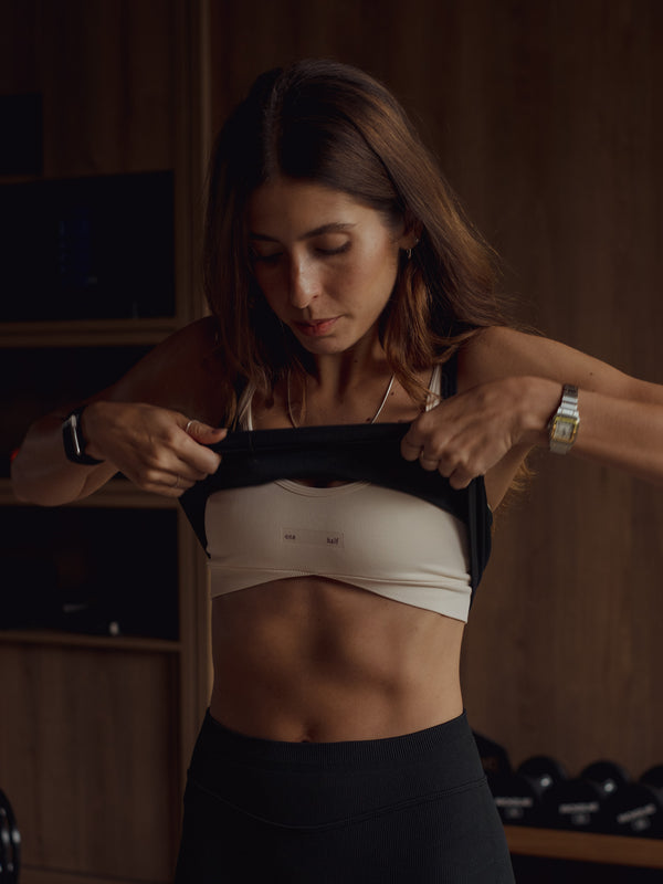 Modelo usando tops deportivos en capas con leggings negro.