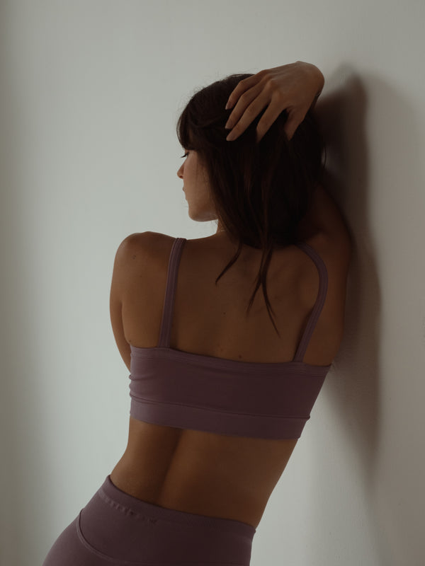 Vista posterior top deportivo rosado de tiras en poliamida sin costuras.