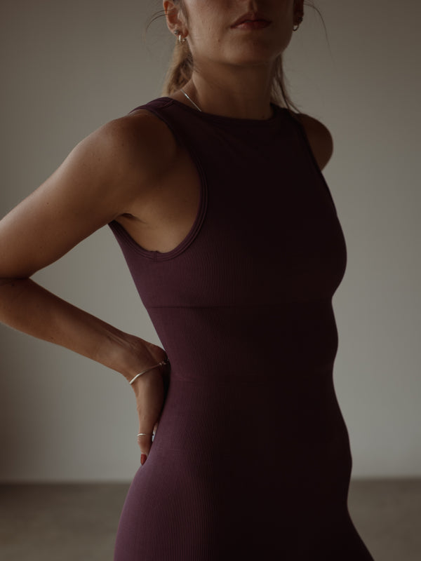 Vista frontal enterizo deportivo vino con control abdomen en poliamida.