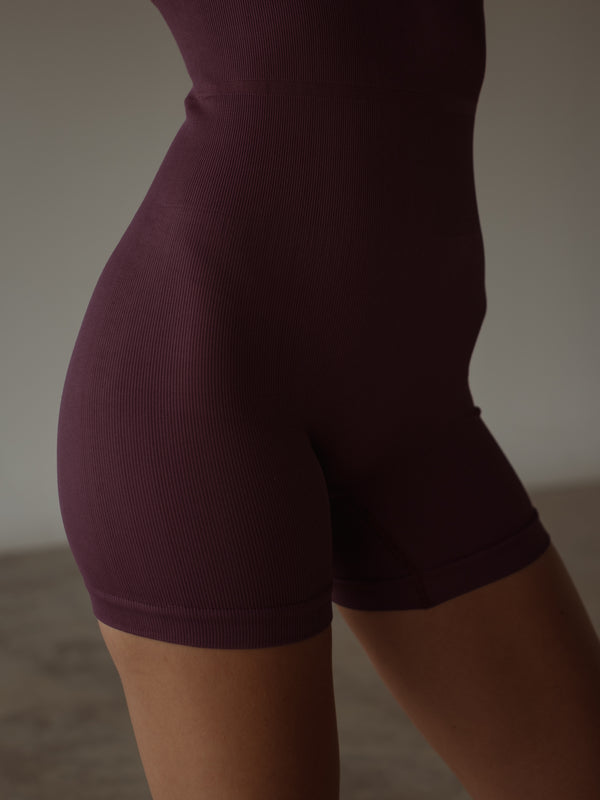 Vista a detalle enterizo deportivo vino en short en poliamida rápido secado.