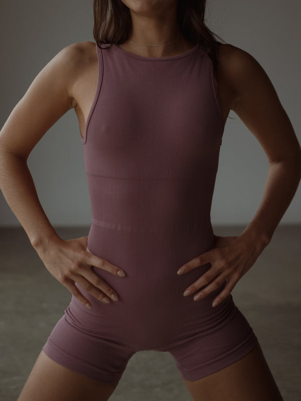 Vista frontal modelo con enterizo deportivo rosado control abdomen.