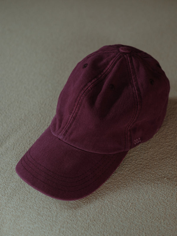 Vista fontal de gorra clásica vino con bordado "One Half" lateral.