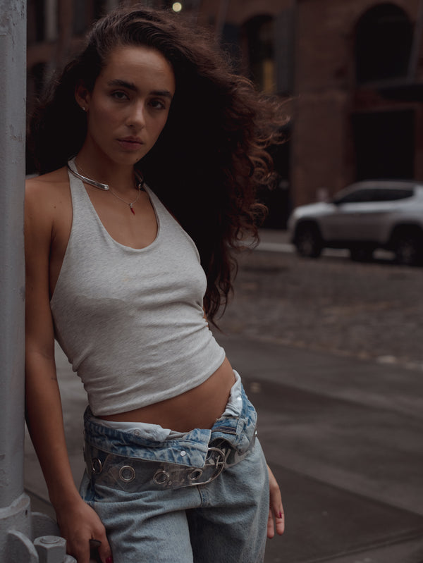 Top con escote U gris con jean doblado en la pretina. 