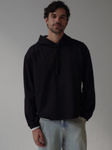 Modelo usando buzo negro con jean azul ahumado. 