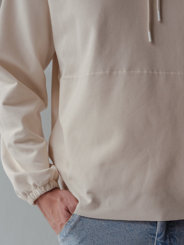 Vista a detalle de manga con elástico de buzo crema de hombre.