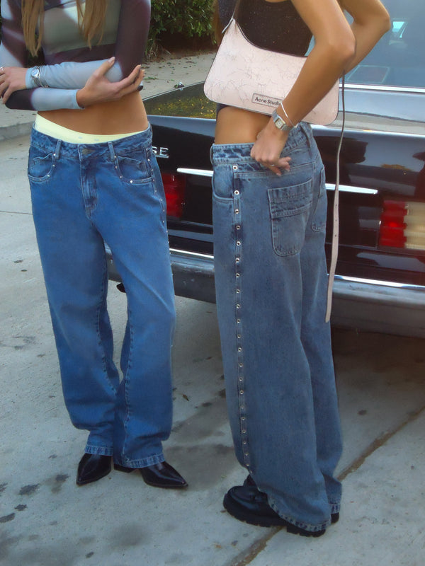 Dos modelos usando jeans azules con crop tops.