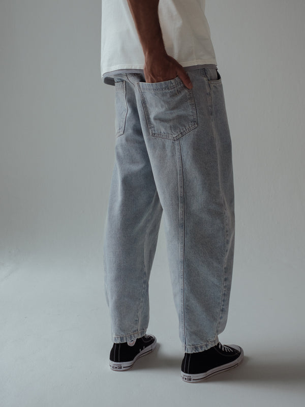 Vista posterior de bolsillos de jean azul claro con costuras visibles para hombre.