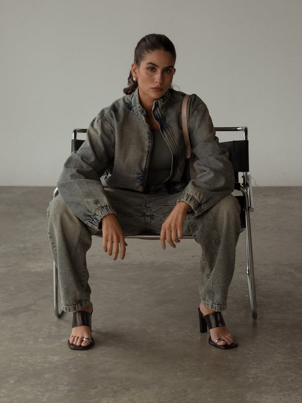 Modelo usando chaqueta y jean con lavado vintage y sandalias de tacón.