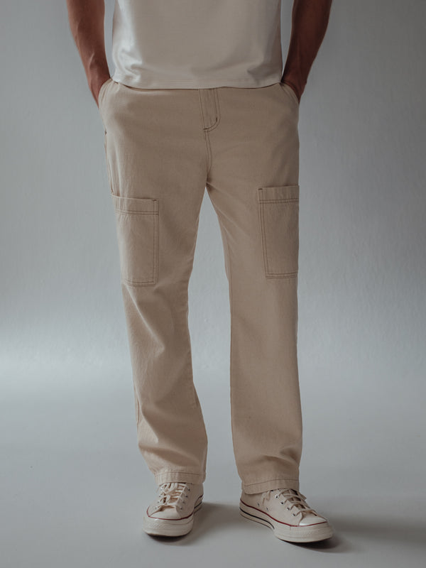 Vista frontal jean crema tipo cargo con bolsillos frontales.