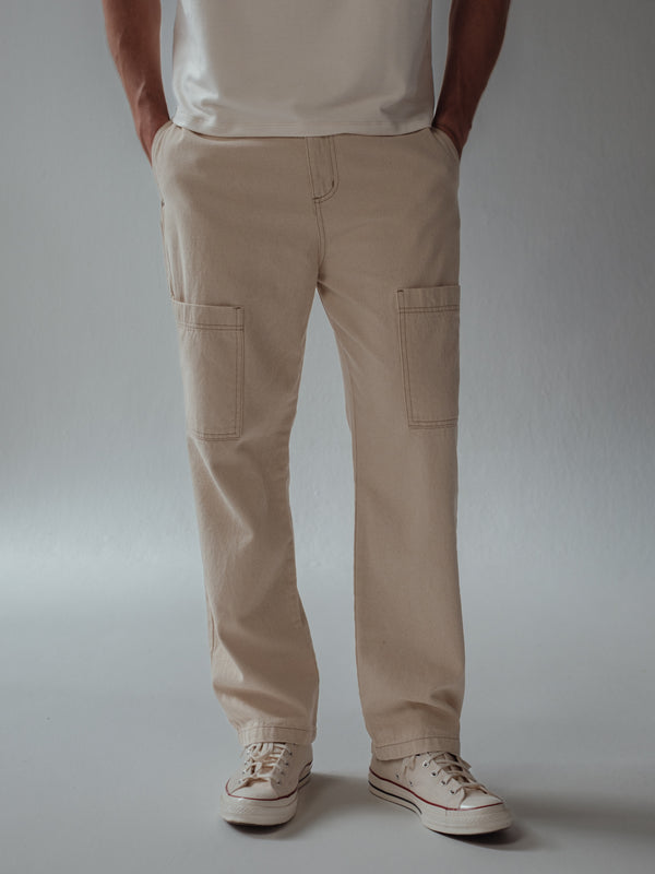 Vista frontal jean crema tipo cargo con bolsillos frontales.