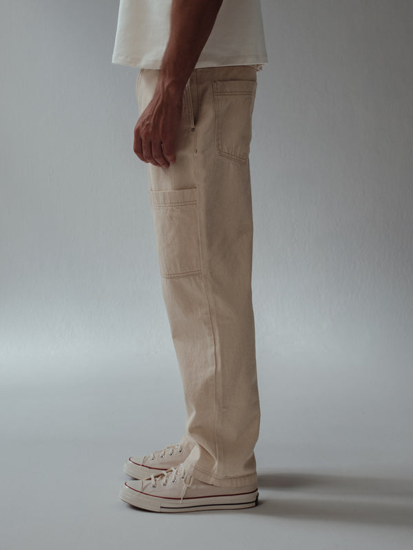 Vista lateral jean crema con bolsillos laterales, posteriores y en la pierna.