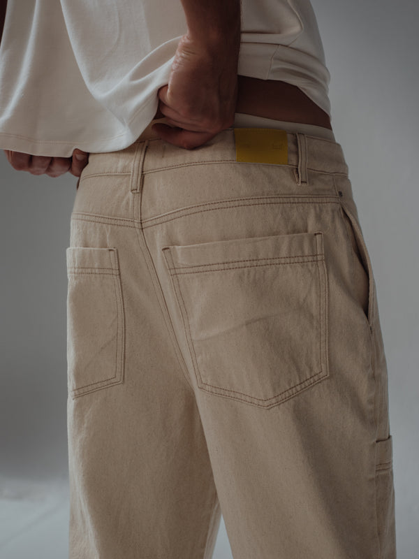 Vista posterior a detalle de bolsillos de jean color crema. 