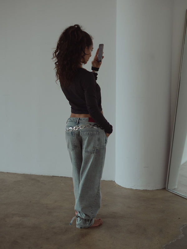 Modelo tomándose una foto en espejo usando un look casual “One Half” 