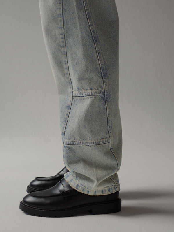 Vista a detalle lateral de jean azul bota recta con costuras asimétricas.