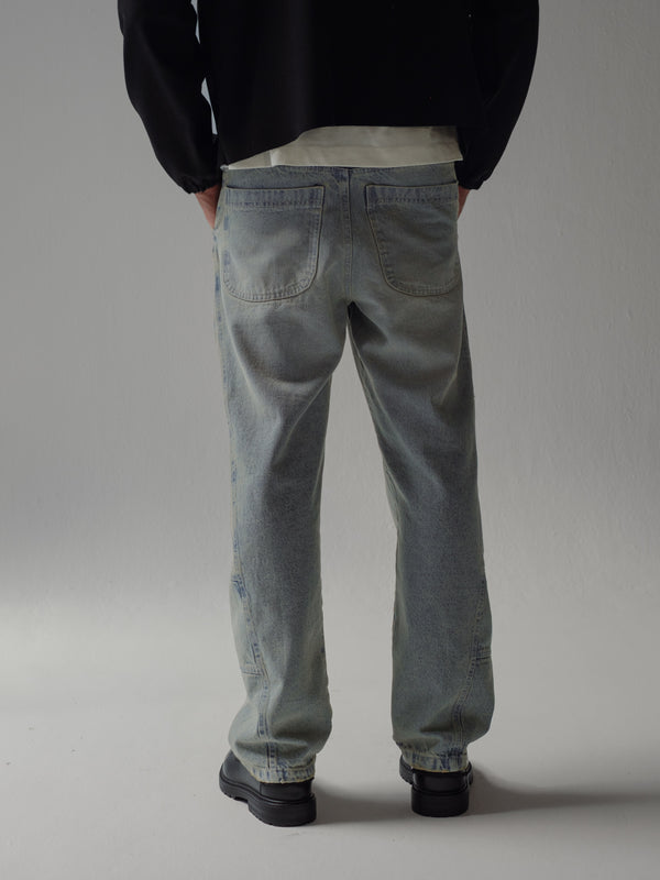 Posterior de jean azul ahumado con bolsillos y costuras visibles. 