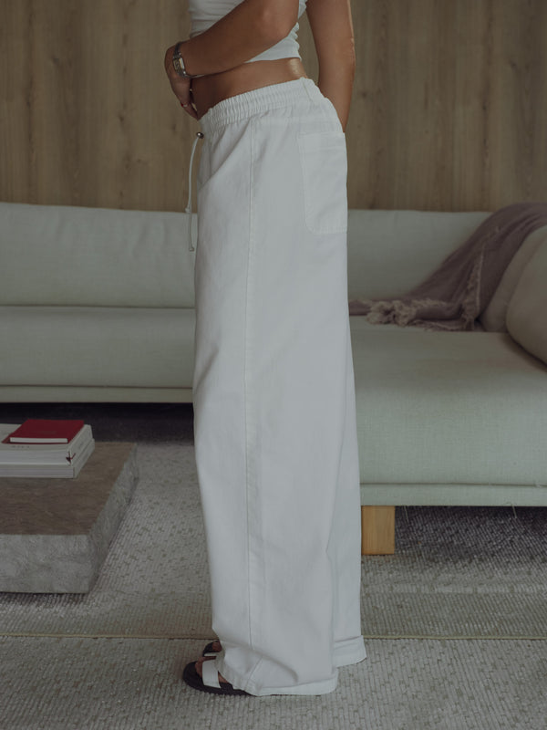 Vista lateral modelo usando jean crudo ajustable bota ancha.