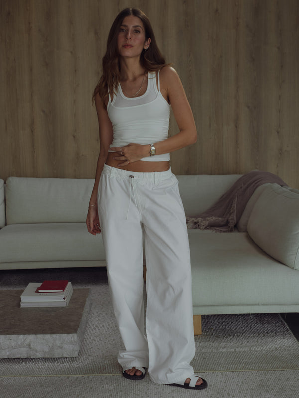 Vista frontal modelo con top tank y jean crudo bota ancha ajustable.