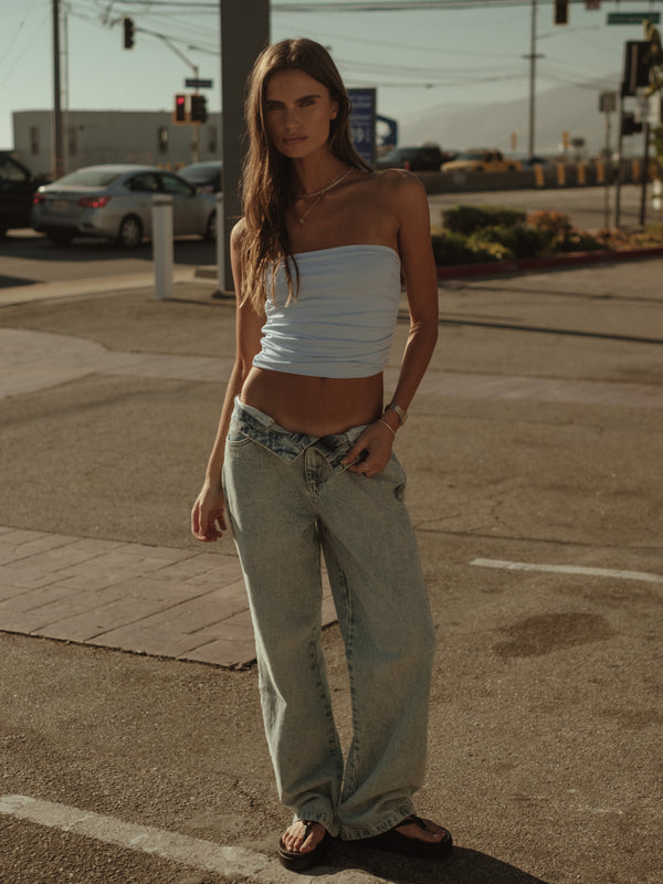 Modelo con top strapless y jean clásico azul claro con sandalias. 