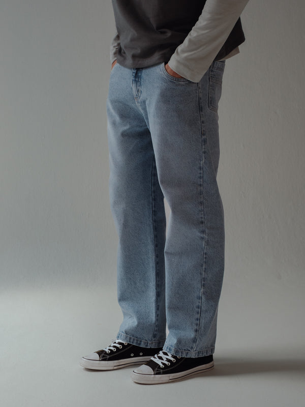 Vista lateral jean azul claro de bota recta para hombre.