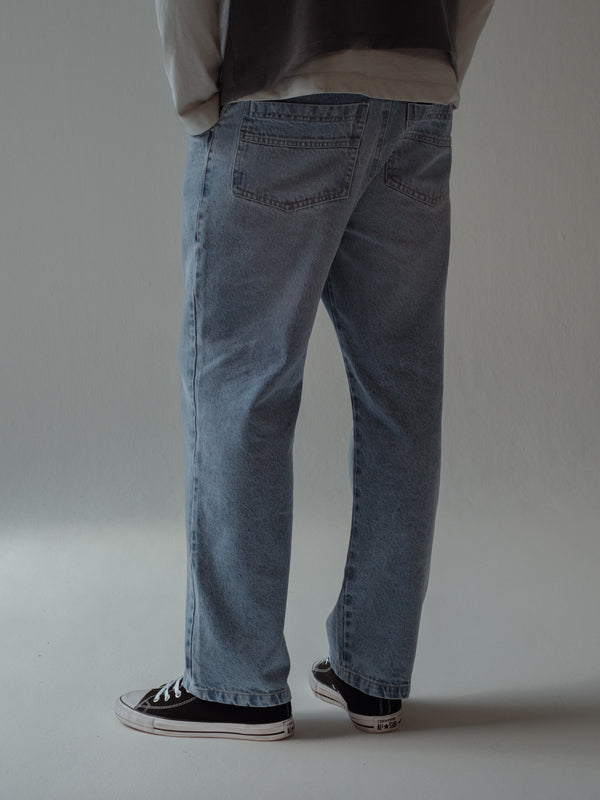 Vista posterior jean azul claro con bolsillos para hombre. 