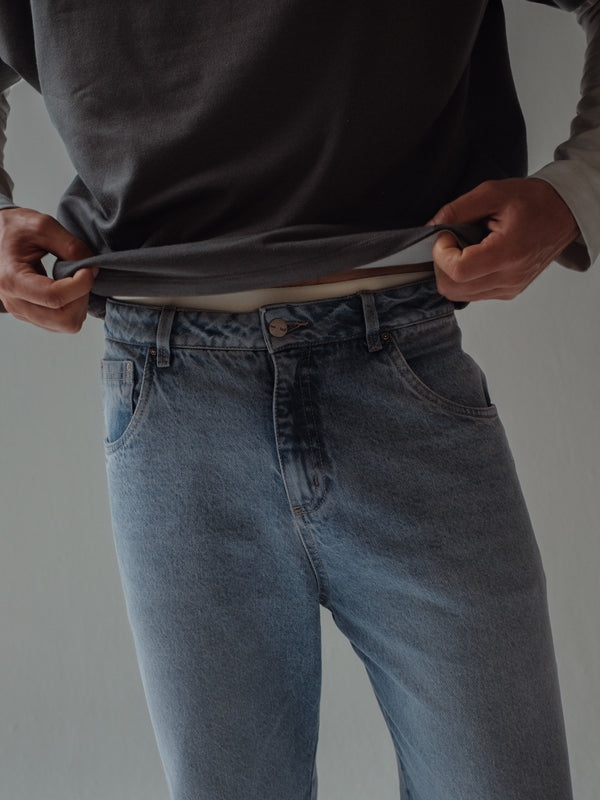 Vista a detalle pretina de jean azul claro bota recta de hombre. 