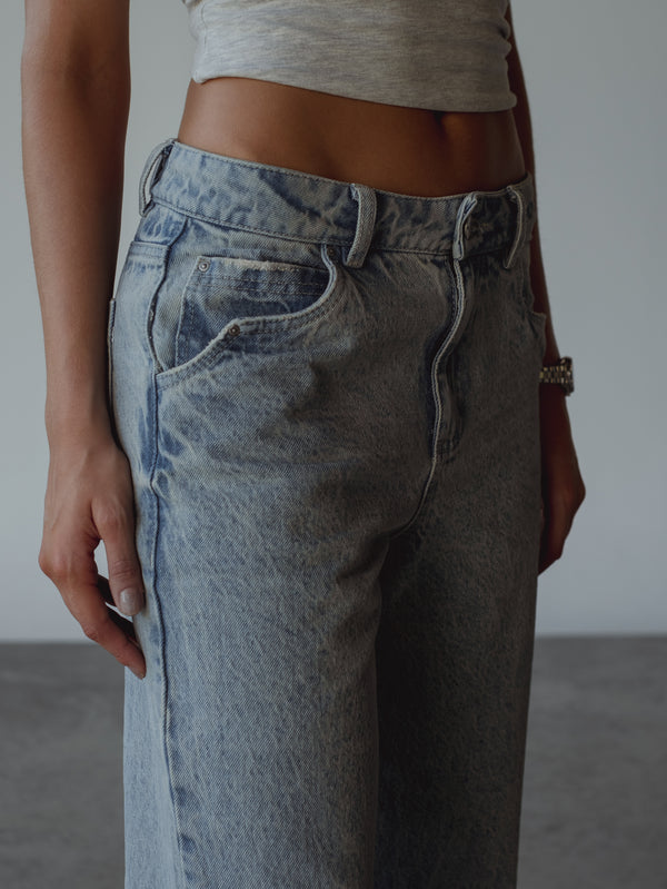 Vista a detalle de bolsillo delantero de jean azul claro.