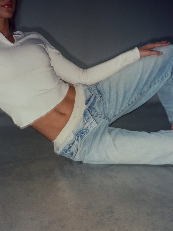 Vista frontal modelo con top y pantie crudo con jean azul clásico.