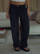 Vista frontal jean negro azul para mujer con sandalias.