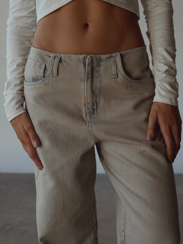 Detalle parte frontal jean sin pretina con pasadores y bolsillos laterales.