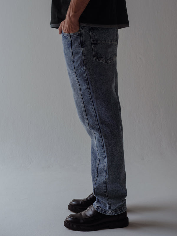 Vista lateral jean clásico azul para hombre con costuras laterales. 