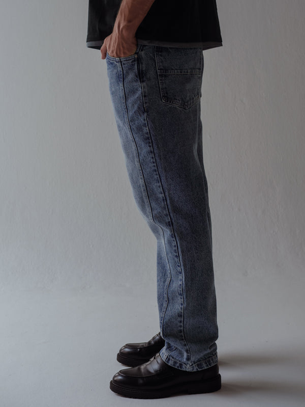Vista lateral jean clásico azul para hombre con costuras laterales. 