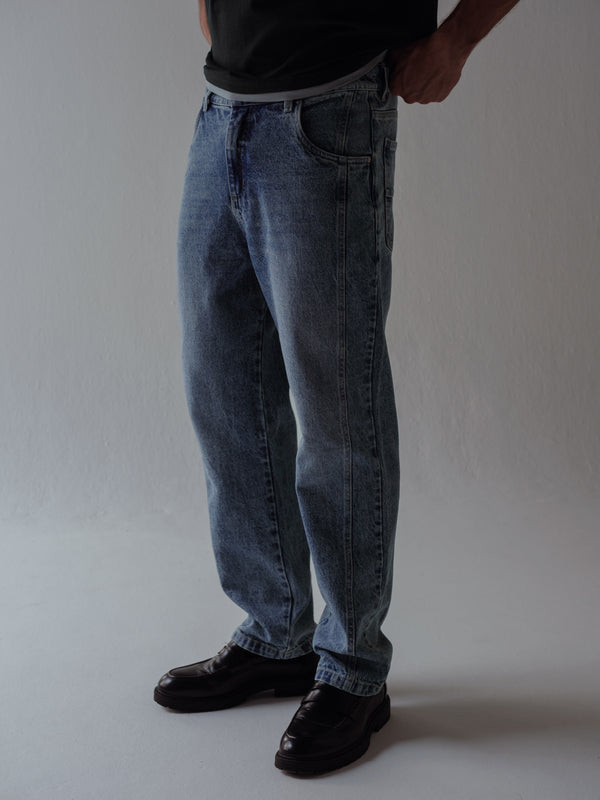 Modelo usando jean azul clásico con zapatos negros.