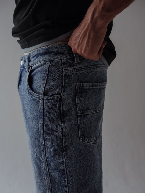 Vista lateral a detalle bolsillos de jean azul clásico para hombre. 