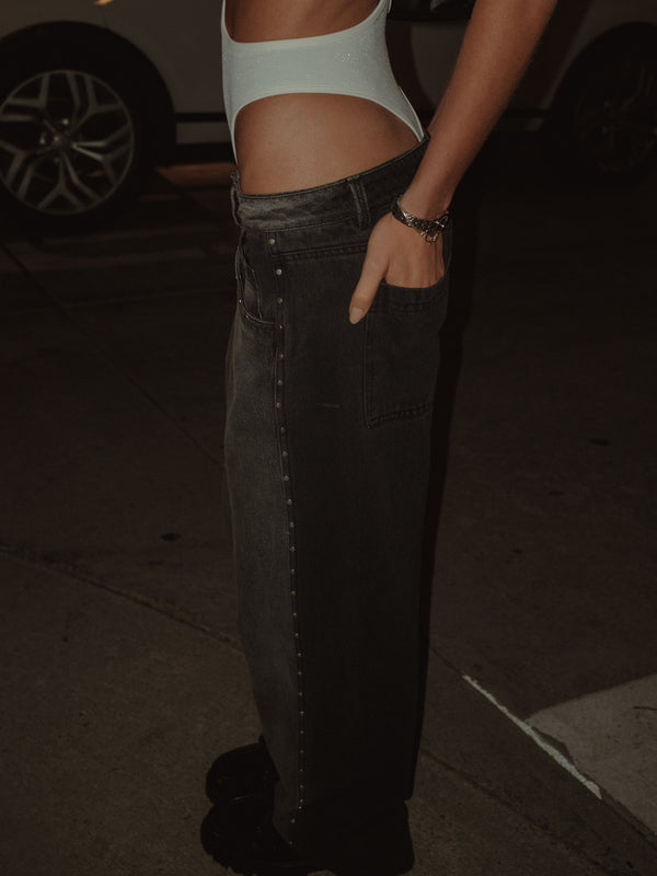 Modelo con jean gris de dos tonos con bodie crema y zapatos negros.