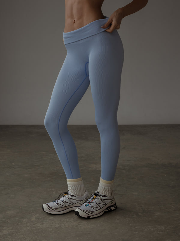 Modelo usando leggings deportivo azul acanalado sin costuras.