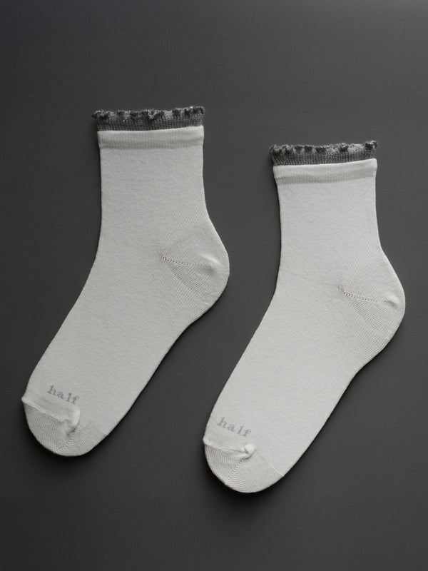 Medias midi blancas con borde ruche gris brillante y "One Half" bordado en punta.