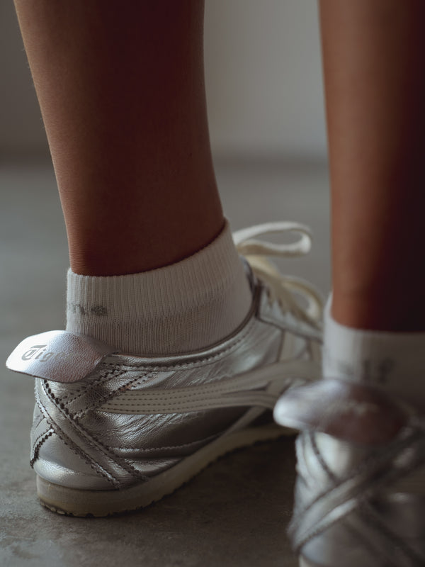 Vista a detalle puño de medias tobilleras blancas. 
