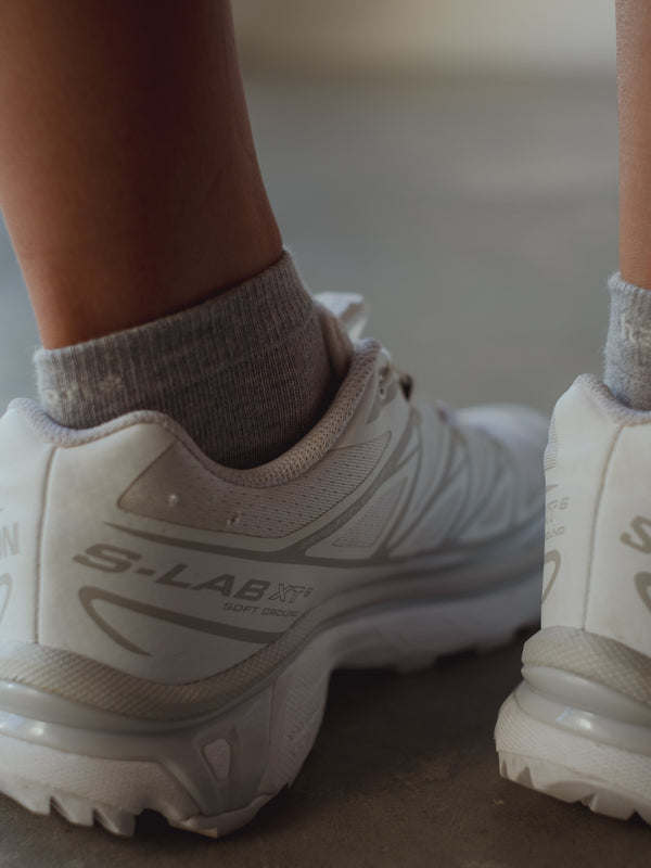 Vista a detalle puño de medias grises tobilleras. 