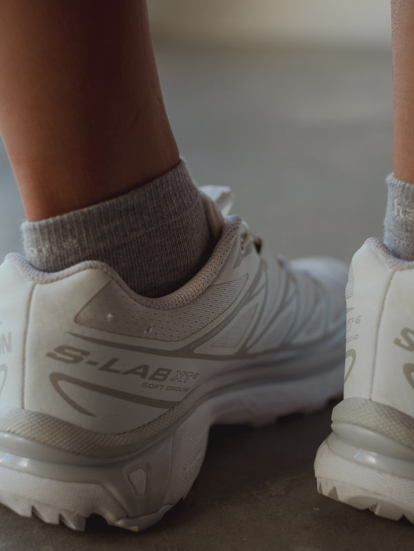 Vista a detalle puño de medias grises tobilleras. 