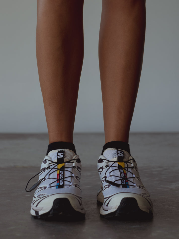 Vista frontal medias tobilleras negras con tenis deportivos.