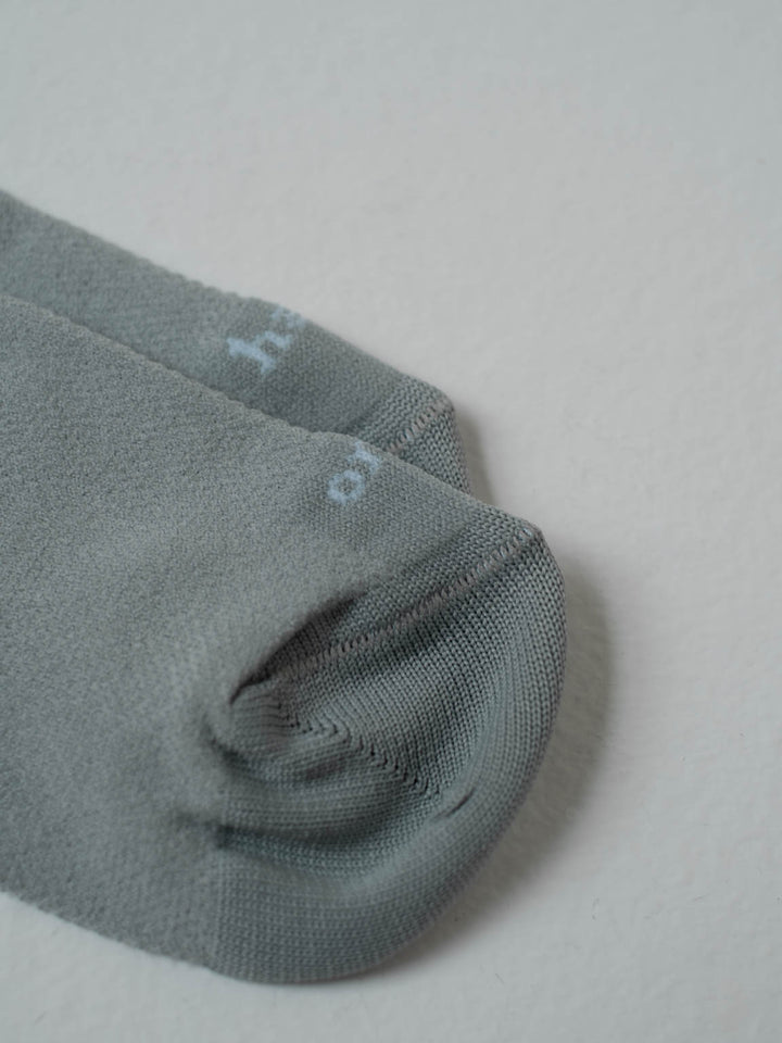 Vista detallada de las medias tobilleras acaneladas color gris con letra One Half color blanco